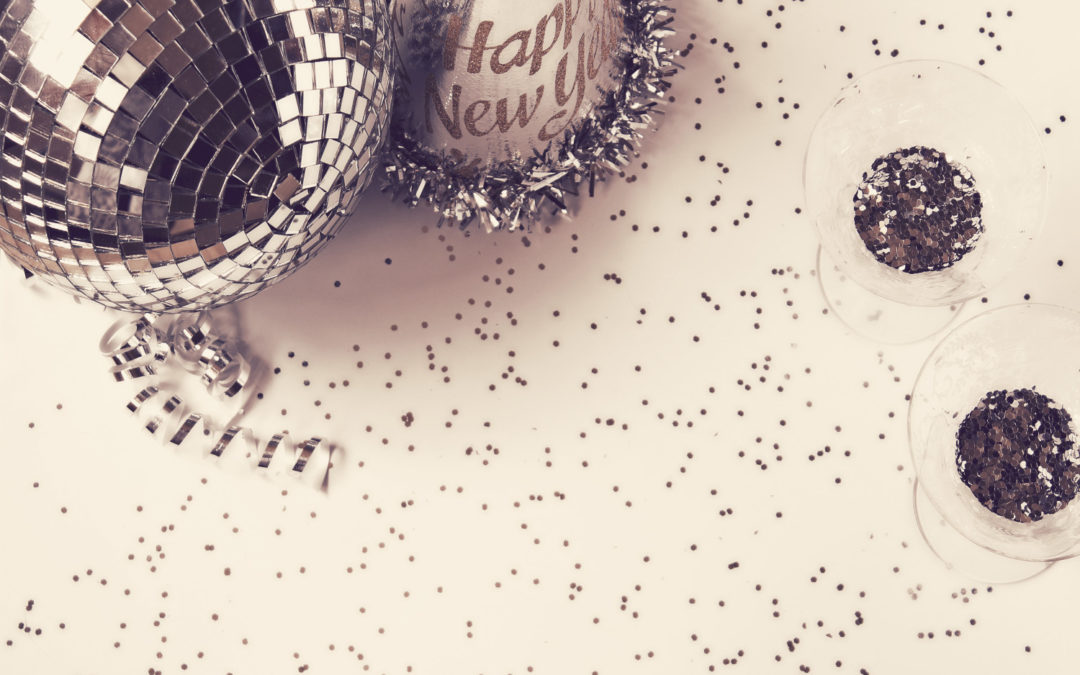 Disco ball and new year's balloon on white, glittery background