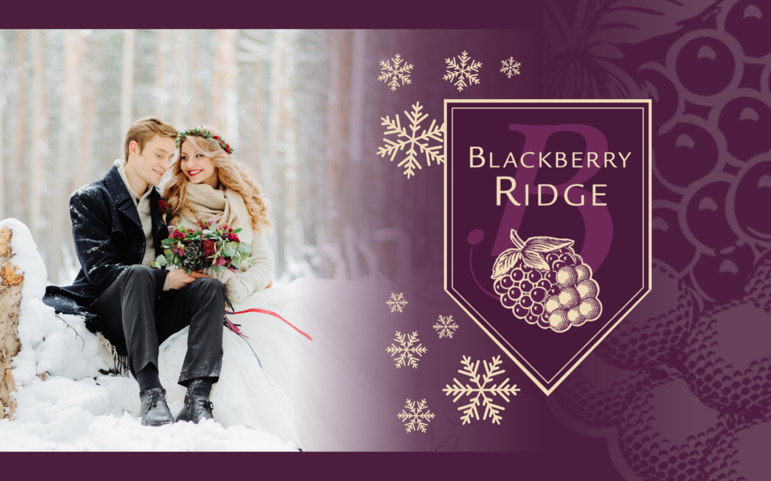 A happy, newlywed couple sit on a fallen tree in the snow. The woman is wearing a thick, warm jacket over her wedding dress, and the man is wearing a block dress jacket. The couple is holding a bouquet of wedding flowers.